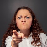 angry young woman pointing at camera