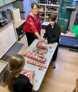 children wrapping gifts for Christmas hype