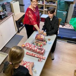 children wrapping gifts for Christmas hype