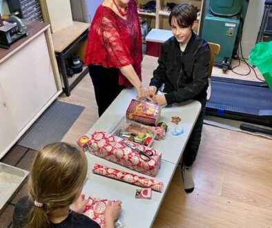children wrapping Christmas gifts