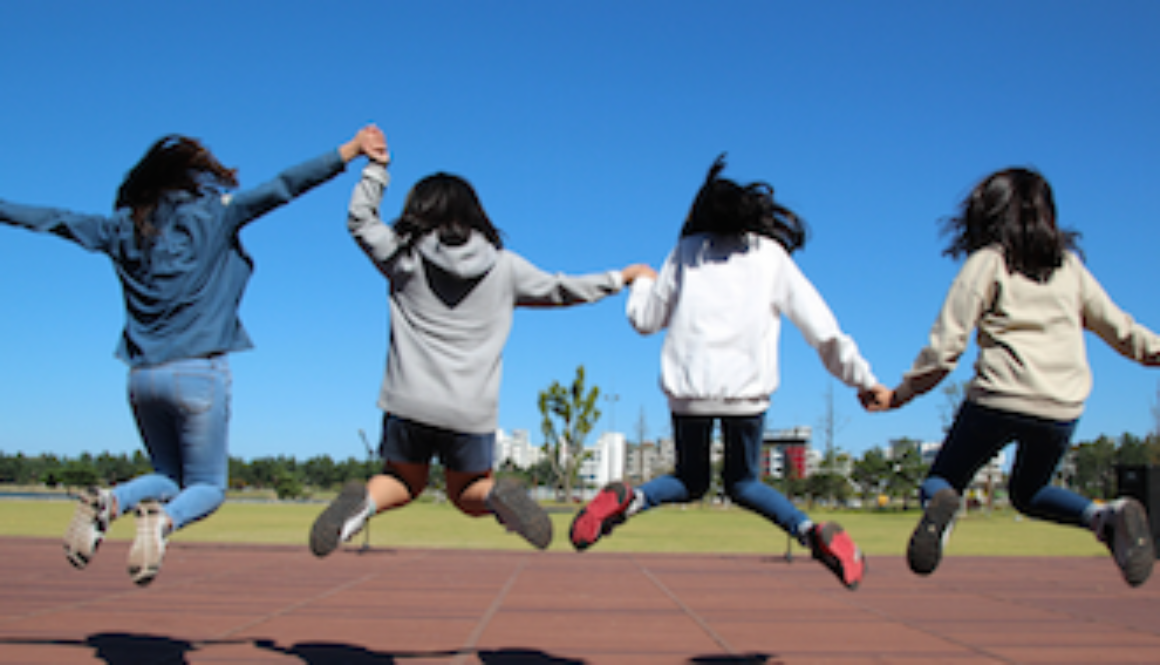 four youth jumping for joy