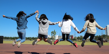 four youth jumping for joy